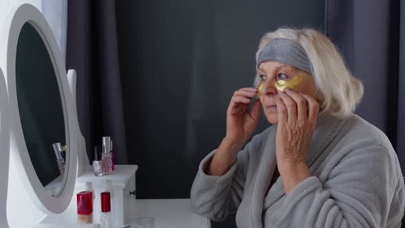 Old Senior Woman Grandmother Taking Care of Skin Near Eyes and Wrinkles, Putting Makeup on at Home