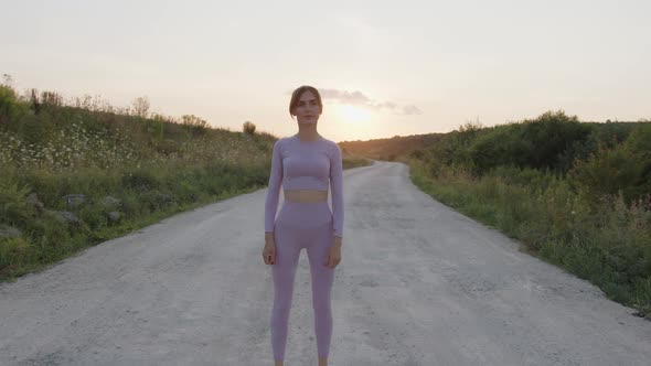 Happy Girl Stands and Starts to Jumping on Road