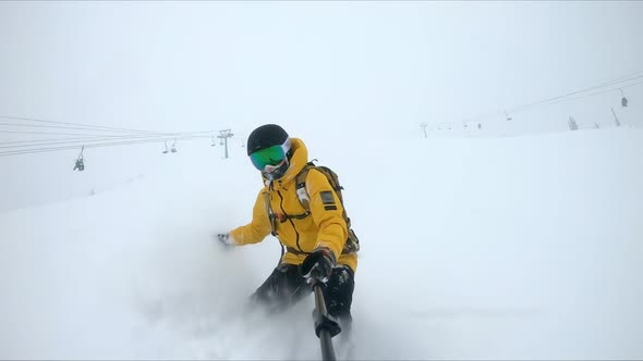 ACTION: A snowboarder rides through deep snow and turns in the fresh powder.