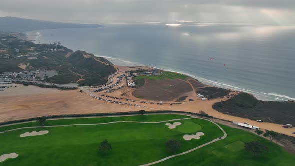wide aerial view over Torrey Pines Golf Course and parking lots above cliffs in La Jolla, San Diego,