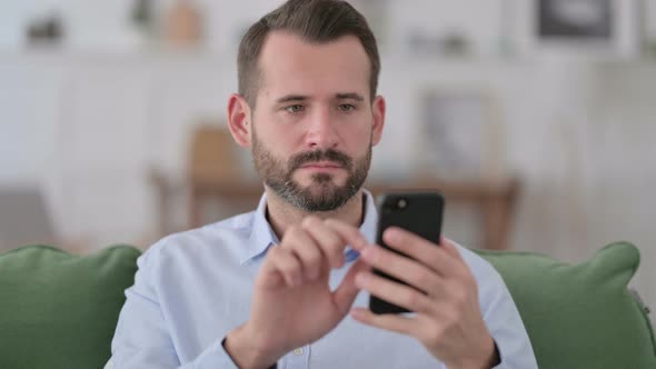 Young Man Using Smartphone at Home 