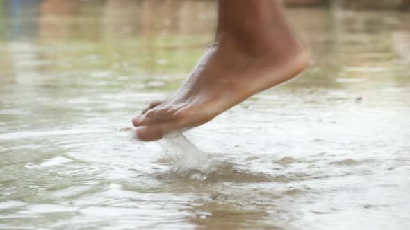 Child Jumping on Water Water After Rain