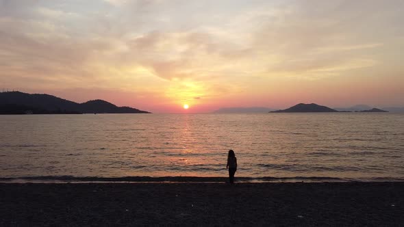 Girl in a peaceful moment watching the famous sunset in Calis Beach, Fethiye - Turkey.