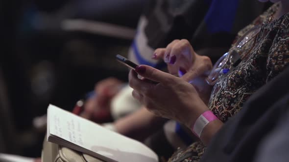 Girl With Notepad Sits In Conference Room And Scrolls The Screen