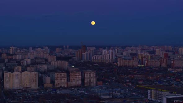 Aerial View of The Huge Moon Above the Night City