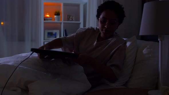Woman with Laptop in Bed at Home at Night