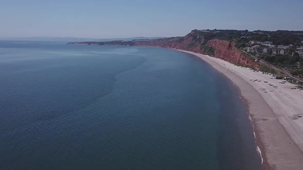 Flying over the ocean water and shore of Budleigh Salterton beach in East Devon England. This locati