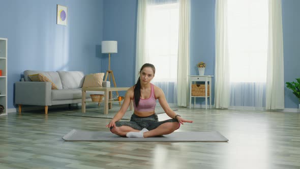 Woman Is Sitting on Fitness Mat and Listen Music