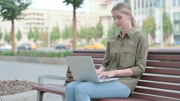 Rejecting Woman in Denial While using Laptop Sitting Outdoor on Bench