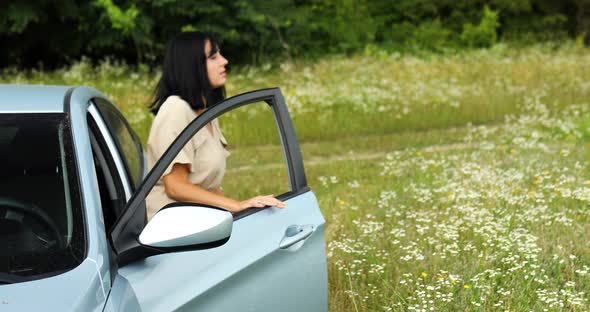Woman Gets Out of the Car Ooking Around and Walking on the Flowers Field Meadow