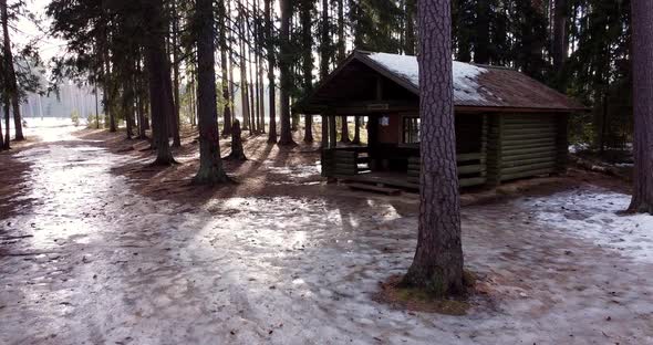 Flying Through Forest Overlooking Log Cabin Covered with Snow