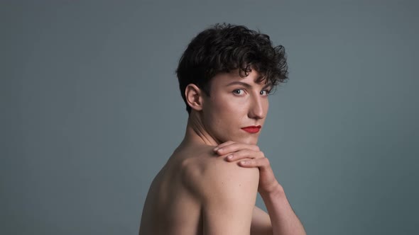 Portrait of a Fashionable Transgender with Makeup Posing on Grey Background