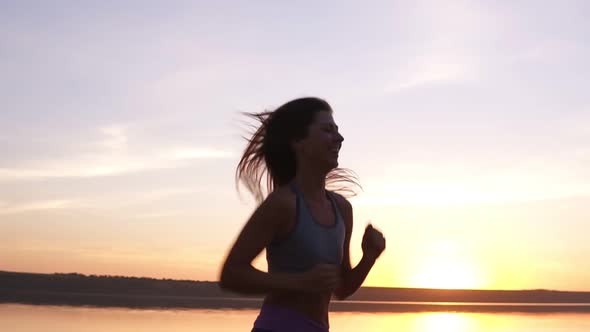 Close Up Footage of a Fit Girl Running Along the Water