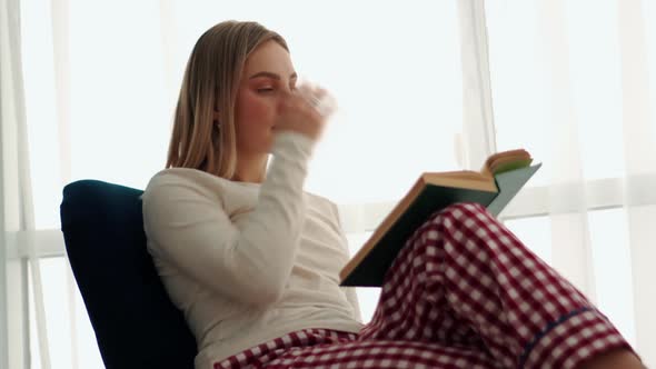 Concentrated blonde woman reading book