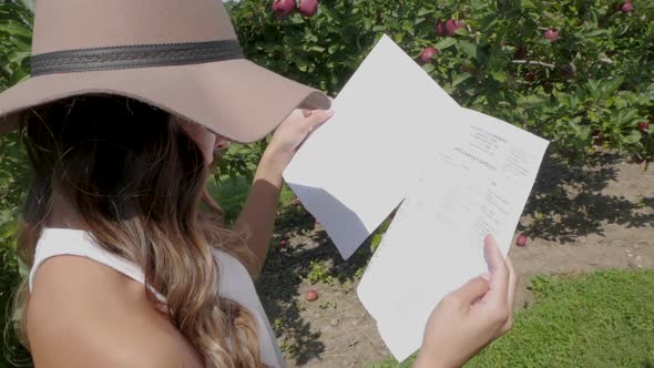 Young woman reads information about the apple harvest.