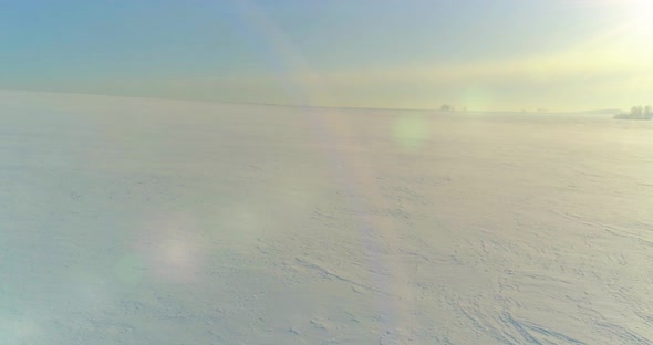 Aerial View of Cold Winter Landscape Arctic Field Trees Covered with Frost Snow Ice River and Sun