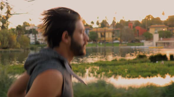 Athletic Man Jogging Around A Small Lake