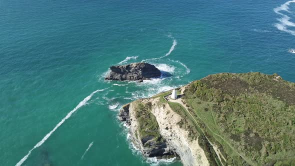 Gull Rock Surrounded By Turquoise Blue Sea In Portreath Cornwall With View Of Pepperpot On A Summer