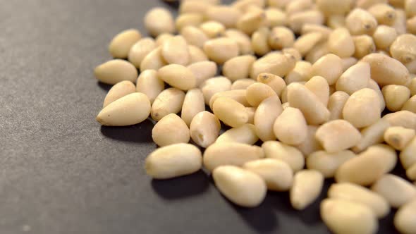 Flax seed heap on dark packaging paper. Brown linseeds. Macro