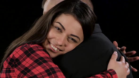 Young Happy Couple Hold Each Other in Lingering Embrace. Black. Close-up