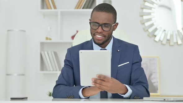 Portrait of Attractive African Businessman Doing Video Call on Tablet 