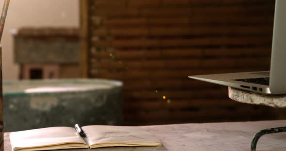 Laptop, opened book, earthenware bowl on a worktop