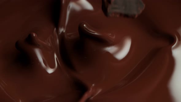 Super Slow Motion Shot of Raw Chocolate Chunks Falling Into Melted Chocolate at 1000Fps