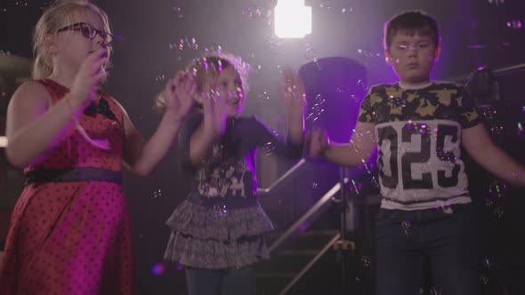 Kids Dancing at a Children's Party with Bubble Machine blowing Bubbles in to Air - Ungraded