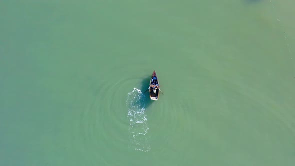 Isolated and unrecognizable fisherman rowing on small boat in calm sea or river waters, Dominican Re