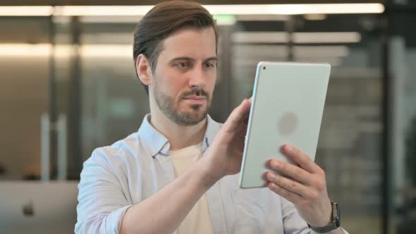 Mature Adult Man Using Digital Tablet Browsing Internet