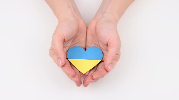Woman Closes Her Palms with a Heart with the Flag of Ukraine