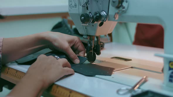 Sewing Machine in a Leather Workshop in Action with Hands Working on a Leather Details for Shoes