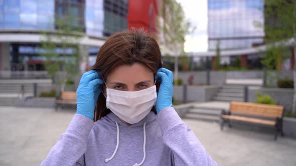 Young Woman on a City Background in a Medical Mask