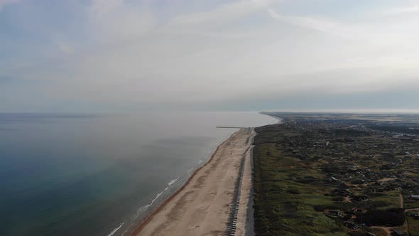 Aerial view of the North Sea shoreline with white bath houses at the beach outside Løkken, Denmark