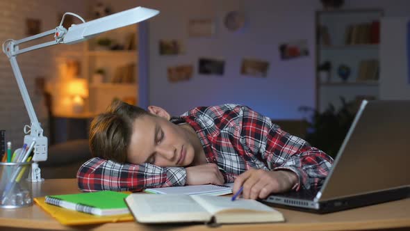 Extremely Tired Student Sleeping by Table on Pile of Books, Overloaded Pupil