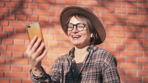 An Attractive Cheerful Woman Taking a Video Call with Her Smartphone