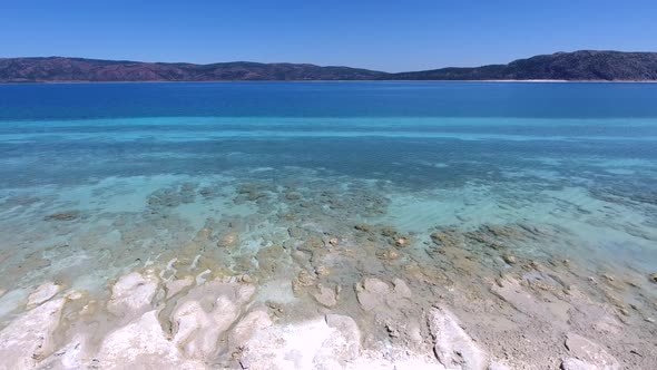 White Sandy Coral Reef in the Clear Turquoise Light Blue Sea of the Tropical Coastline