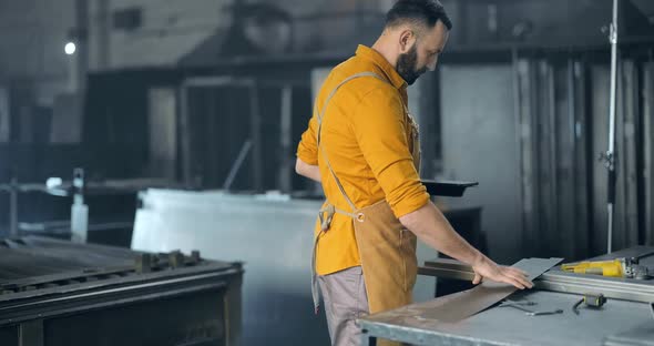 Factory Worker with Tablet and Phone at the Manufacturing