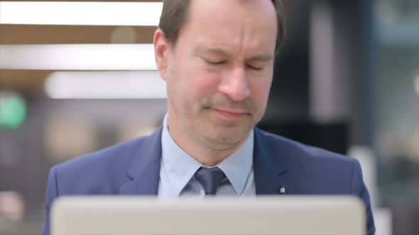 Portrait of Businessman Reacting to Loss on Laptop