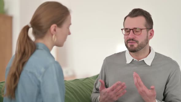 Man Arguing with Woman While Sitting on Sofa Fighting