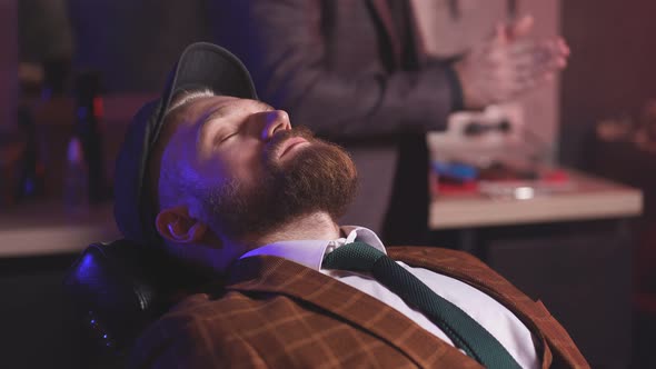 Male Barber Preparing Client for Cutting Beard