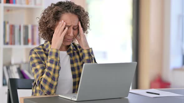 Young Mixed Race Woman with Headache Using Laptop at Work 