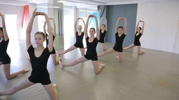 Girls Stand In Pose And Do Stretching Exercise In Dancing Class