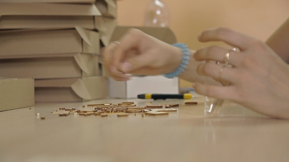 A Woman Collects Items From The Plywood Into The Package