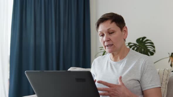 Smiling Elderly Mature Woman Chatting on Social Networks at Home