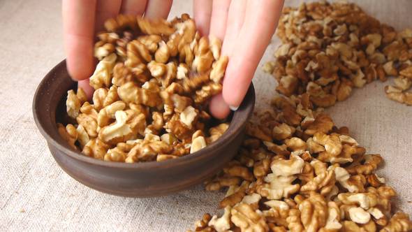 Pooring Walnut Kernels Into Ceramic Bowl