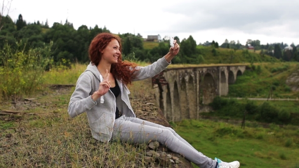 Girl Doing Selfie Sitting On The Old Viaduct