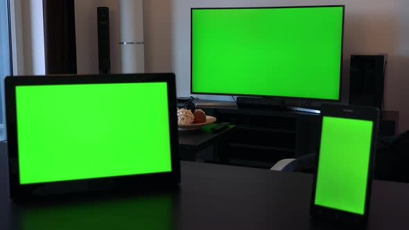 A Tablet (Horizontal) and a Smartphone (Vertical) on a Desk, a TV in the Background - Green Screen