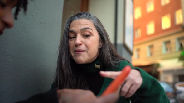 Cheerful black woman showing smartphone to ethnic friend