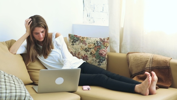 Young Woman Using Laptop On The Sofa